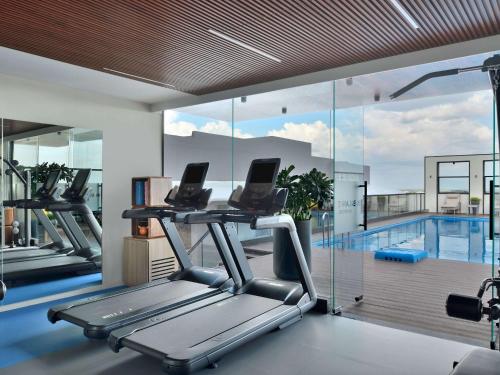 a gym with a treadmill and a swimming pool at Novotel Jodhpur ITI Circle in Jodhpur