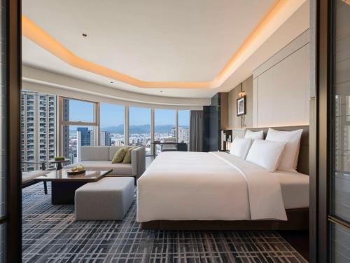 a hotel room with a bed and a couch at Pullman Quanzhou Shuitou in Quanzhou