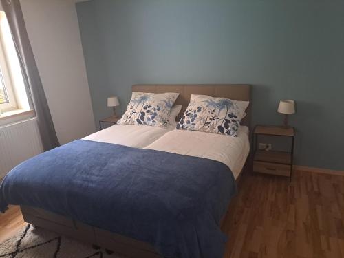um quarto com uma cama grande com lençóis e almofadas azuis em Haus am Schloss em Bleiburg