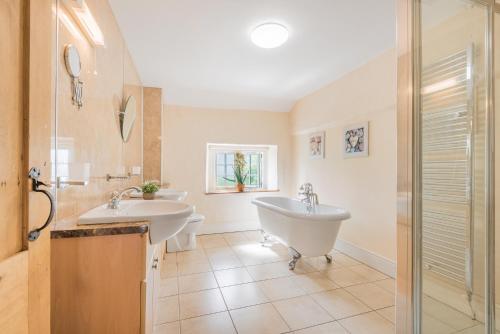 a bathroom with two sinks and a shower at farmhouse braithwaite mews in Keswick