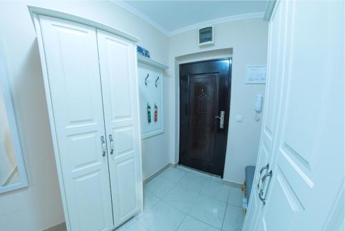 a hallway with white cabinets and a black door at Apartman Centar in Požarevac