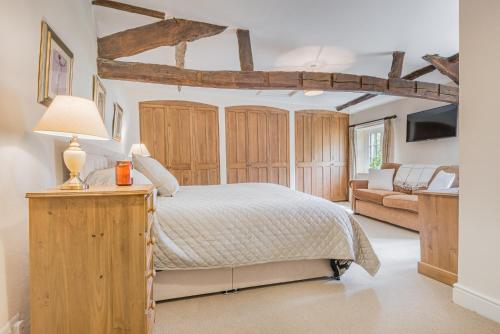 a bedroom with a bed with wooden cabinets and a couch at farmhouse braithwaite mews in Keswick
