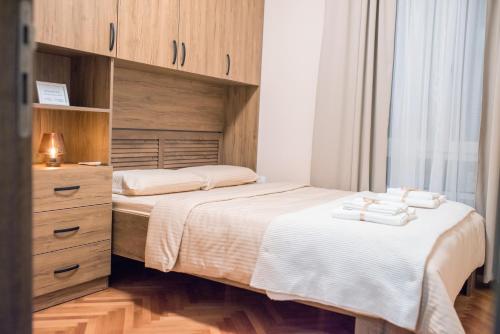 Apartman Centar في بوزاريفاتش: غرفة نوم بسريرين وخزانة