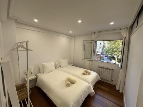 1 dormitorio con 2 camas y ventana en Apto reformado a 20 mins de la playa en Pasajes Ancho