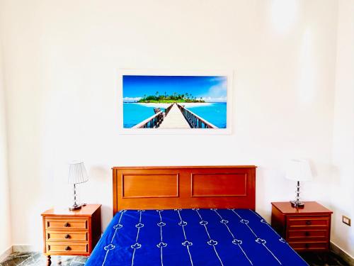 Un dormitorio con una cama azul y dos mesitas de noche. en Calabria Experience ****, en Montegiordano