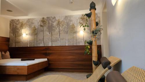 ein Schlafzimmer mit einem Bett und einem Wandgemälde in der Unterkunft Hotel Untersberg in Sankt Leonhard