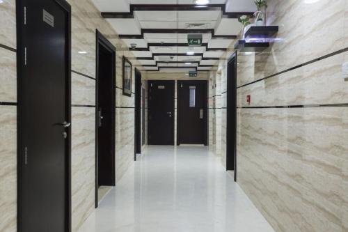 an empty hallway in a building with black doors at Flexible Small Partition Room Near MOE in Dubai