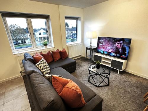 a living room with a couch and a flat screen tv at Walnut Flat, 2-Bedroom with Ensuite - Parking, Netflix, WIFI - Close to Oxford, Bicester & Blenheim Palace - F4 in Oxford