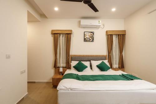 a bedroom with a large bed with green pillows at SpringPetals Serviced Apartments in Bangalore