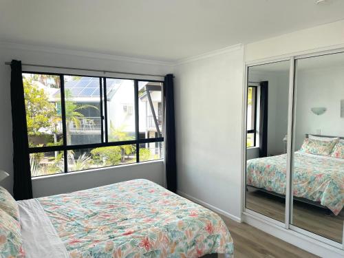 a bedroom with two beds and a large window at 1 Bedroom Unit in 4 Star Tropical Resort in Noosaville in Noosaville