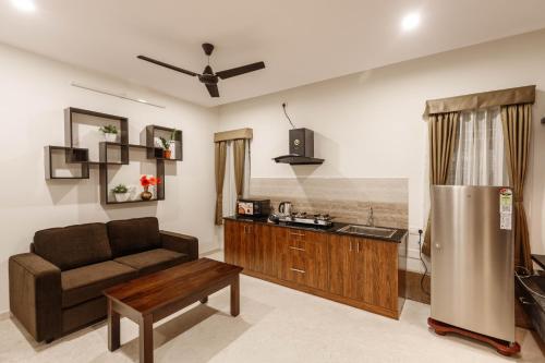a living room with a couch and a kitchen at SpringPetals Serviced Apartments in Bangalore