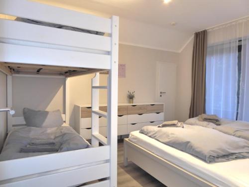 Un dormitorio con dos literas y un escritorio. en Family Star Winterberg Ferienwohnung 6 Pers Wifi Pool near Bikepark, en Winterberg