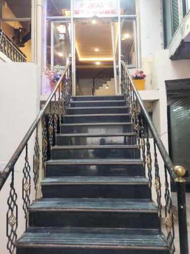a staircase in a building with a person walking down it at Hotel Always Welcome by SAH in Mount Ābu