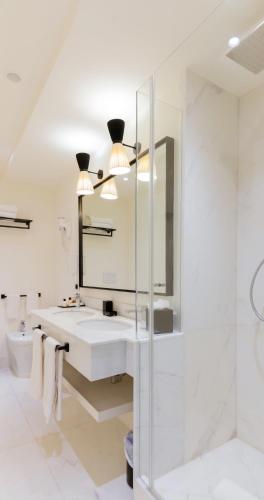 a white bathroom with a sink and a mirror at California Park Hotel in Forte dei Marmi