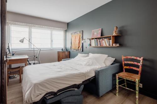 une chambre avec un lit, un bureau et une chaise dans l'établissement Veeve - Artistic Poise, à Boulogne-Billancourt