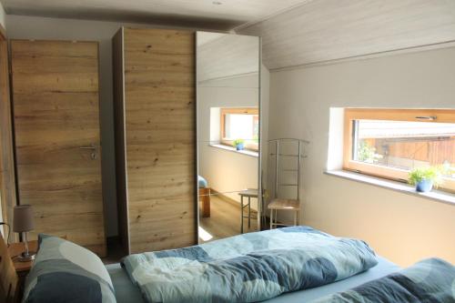 1 dormitorio con una gran puerta corredera y 1 cama en Ferienwohnung Pfrang en Michelau