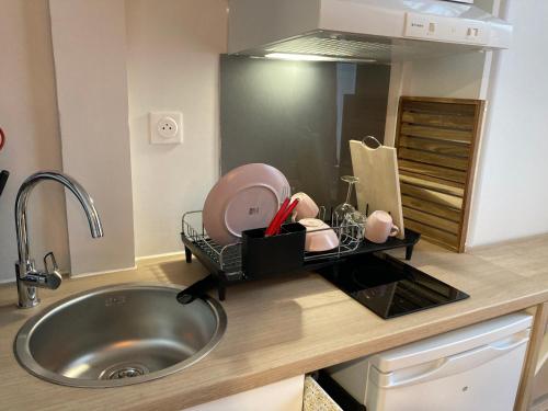 eine Küchentheke mit einem Waschbecken und einem Waschbecken in der Unterkunft Exceptionnel au coeur de Lille in Lille