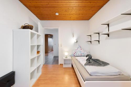 1 dormitorio con paredes blancas y 1 cama en una habitación en Ferienwohnungen Lilie Und Dahlie en Münsingen