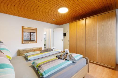 2 camas en un dormitorio con armarios de madera en Ferienwohnungen Lilie Und Dahlie en Münsingen