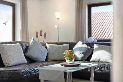 a living room with a leather couch and a table at Ferienwohnungen Lilie Und Dahlie in Münsingen