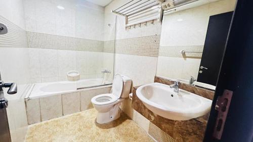 a white bathroom with a toilet and a sink at Brand New Private Partition Near MOE Metro in Dubai