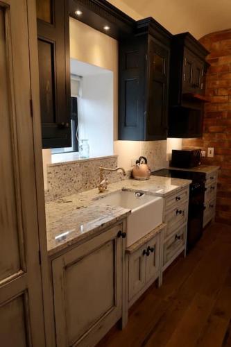 a kitchen with a sink and a stove at Tara’s Hill Cottage in Kilcoo
