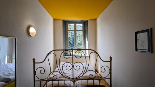 Cama en habitación con ventana en Wild Valley Hostel - Villa Edera en Auressio