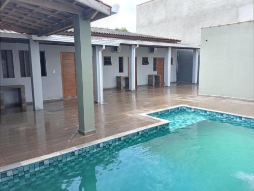 a swimming pool in the middle of a house at Cantinho do Sossego - kitnets in Cananéia