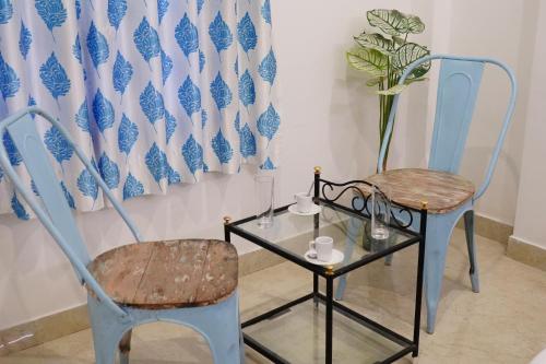 twee stoelen en een tafel en een vaas bij Rising Shemesh Home Stay in Udaipur