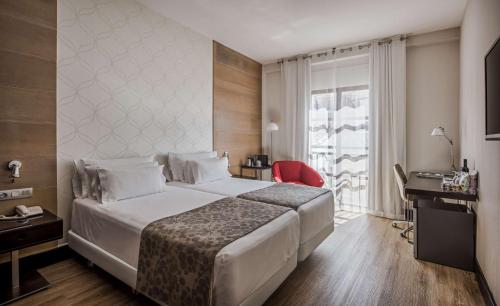 a hotel room with a large bed and a window at NH Collection Amistad Córdoba in Córdoba