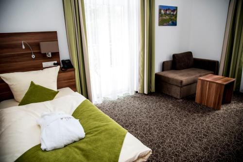 a hotel room with a bed and a chair at Hotel Villa Elsa in Bad Kissingen