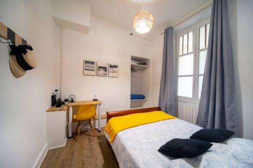 une chambre avec un lit, un bureau et une fenêtre dans l'établissement Cabana & Le Sirène - Proche Centre-Ville, à Mâcon