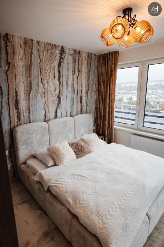 a bedroom with a large bed with a wooden wall at AH Albelli II in Košice