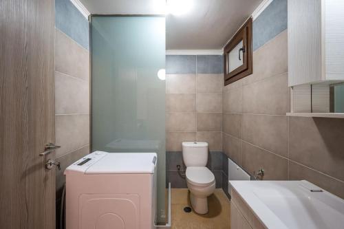 a small bathroom with a toilet and a sink at Archanes Luxury Apartment in Archanes