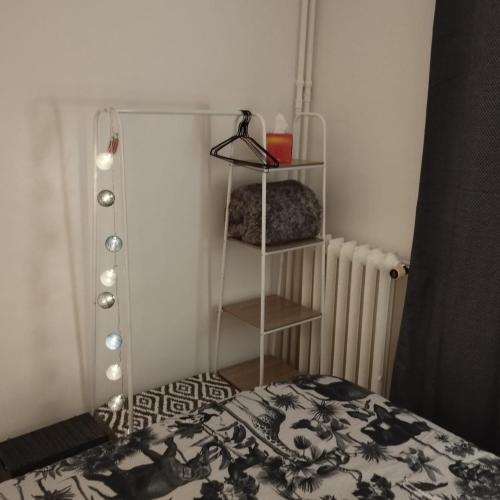 um quarto com uma cama com um cobertor preto e branco em Home sweet to Paris em Clichy