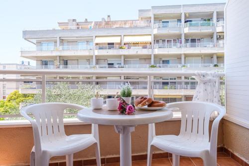 a table with a plate of food on a balcony at Apartamentos California in Salou