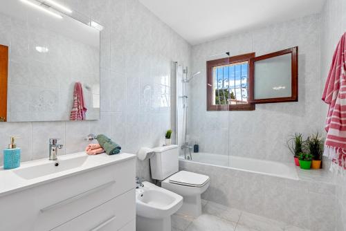 een badkamer met een toilet, een wastafel en een bad bij Villa Agudin - PlusHolidays in Calpe