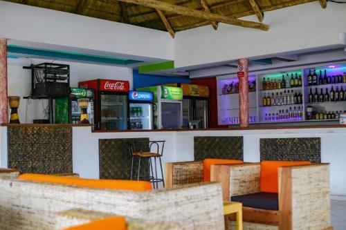 ein Restaurant mit orangefarbenen Stühlen und einer Bar in der Unterkunft Kakiri Gardens and Hotel in Wakiso