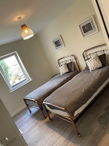 two beds in a room with a window at 15 Waterwheel Wharf, Annalong in Newry