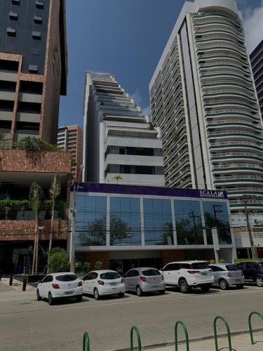 een parkeerplaats met auto's voor gebouwen bij Adriana Flats - Sem vista mar e sem varanda in Fortaleza