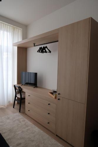 a room with a wooden cabinet with a television and a desk at Apartamentos sobre o Douro in Porto