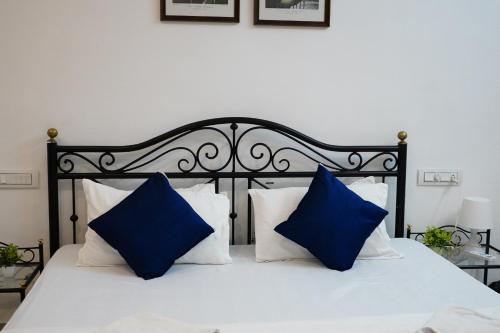 a bed with blue and white pillows on it at Rising Shemesh Home Stay in Udaipur