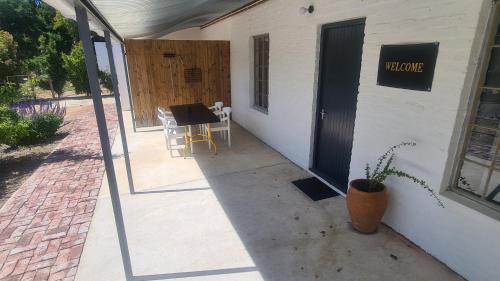a door to a building with a table and chairs at Peacock Guesthouse in Tulbagh