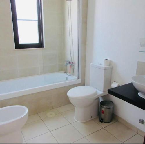 a bathroom with a toilet and a tub and a sink at Tranquil Apartment at Tortuga Beach - 221 in Prainha