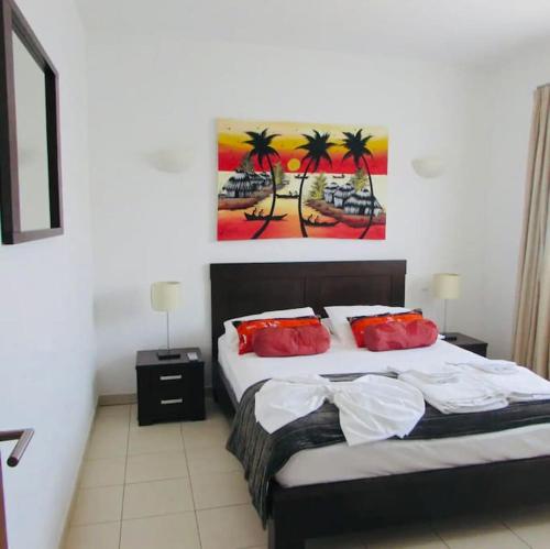 PrainhaにあるTranquil Apartment at Tortuga Beach - 221のベッドルーム1室(壁に絵画が描かれたベッド1台付)