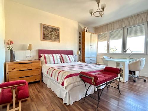 um quarto com uma cama, uma secretária e uma mesa em Hispalis Ático Bermejales em Sevilha