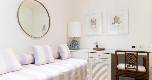 a white room with a couch and a mirror at California Park Hotel in Forte dei Marmi