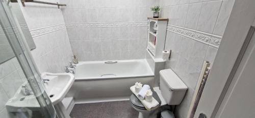 uma casa de banho com uma banheira, um lavatório e um WC. em MarMic Cottage em Rothbury