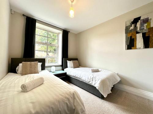 um quarto com 2 camas e uma janela em Desirable 2 Bedroom Apartment in Bicester that sleeps 5 em Bicester