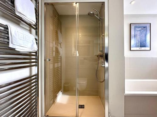 La salle de bains est pourvue d'une douche avec une porte en verre. dans l'établissement Desirable 2 Bedroom Apartment in Bicester that sleeps 5, à Bicester